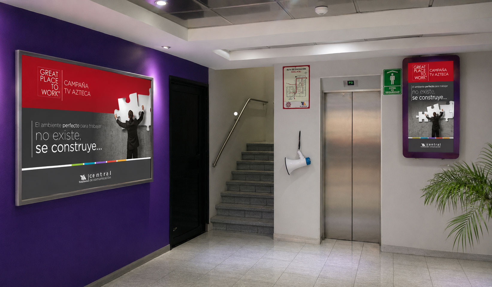Pasillo con muro morado y póster "El ambiente perfecto para trabajar no existe, se construye..." de la campaña