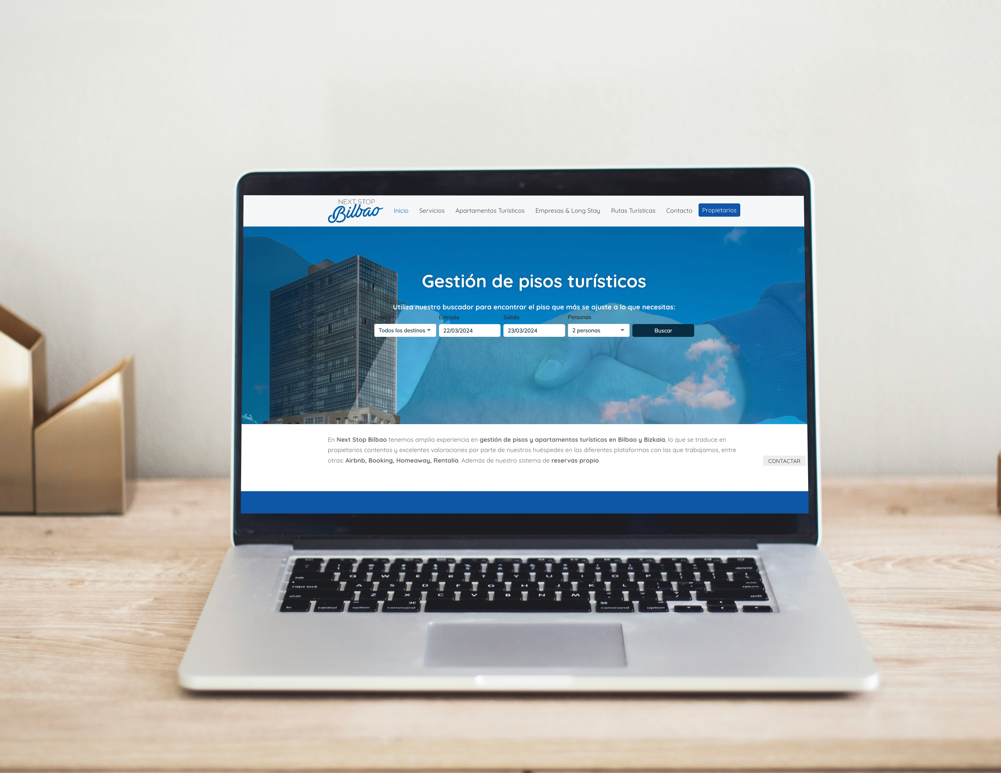 Laptop sobre un escritorio de madera con el sitio web de Next Stop Bilbao para la gestión de apartamentos turísticos