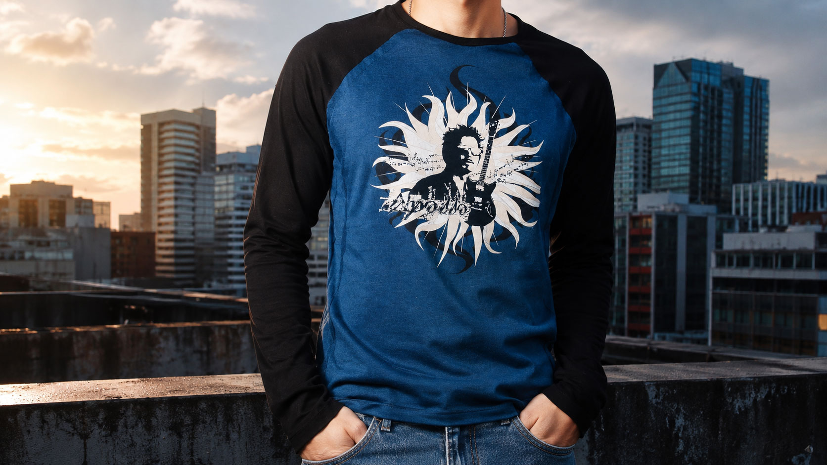 Hombre con una playera raglán azul y negra con un gráfico de retrato en forma de sol, con el perfil de una ciudad al fondo