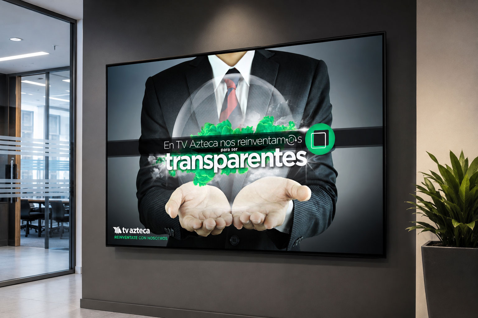 Pantalla en una oficina con el mensaje "En TV Azteca nos reinventamos para ser transparentes"