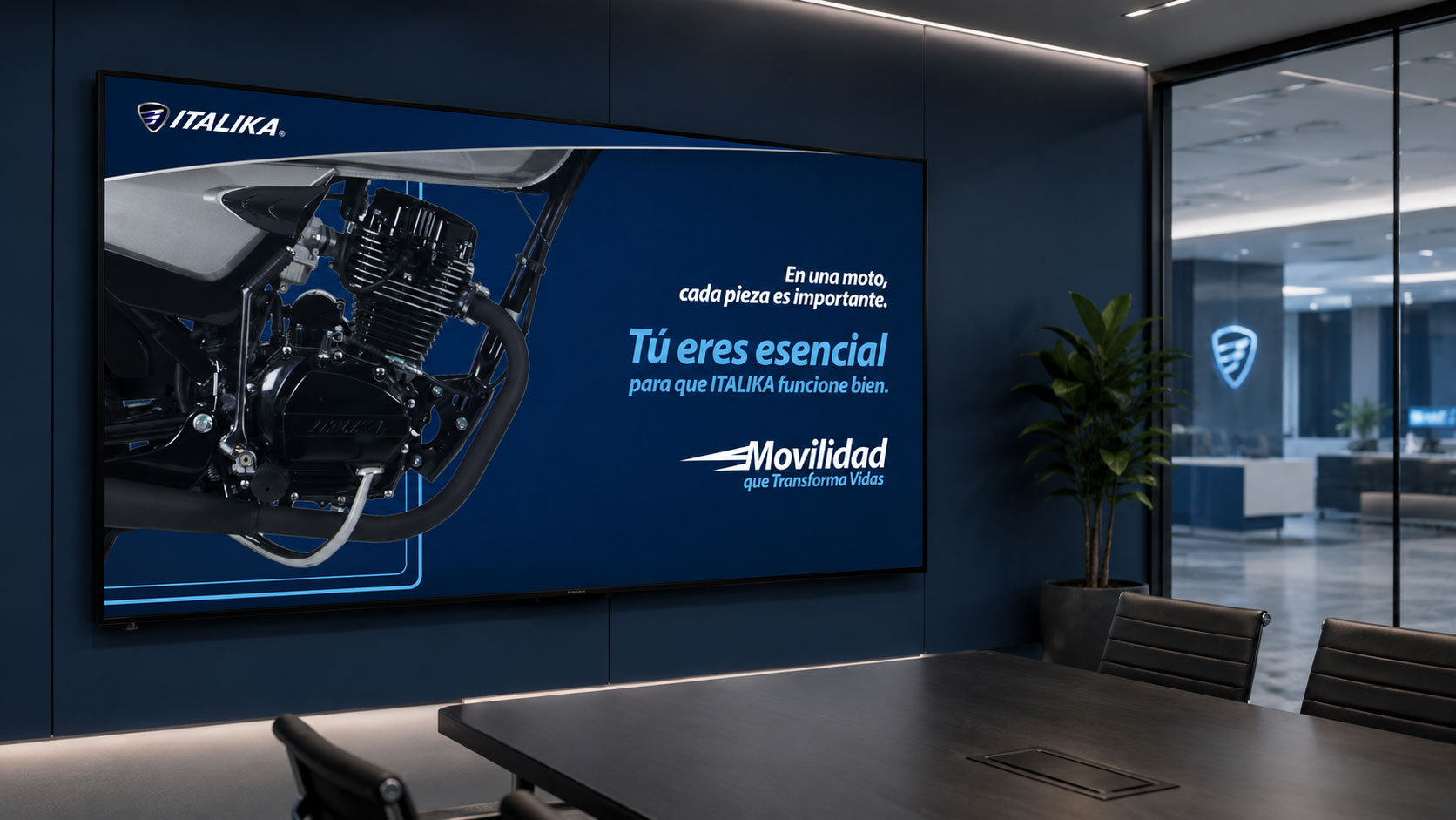 Pantalla en una sala de juntas con un motor de moto y el mensaje "Tú eres esencial para que ITALIKA funcione bien"