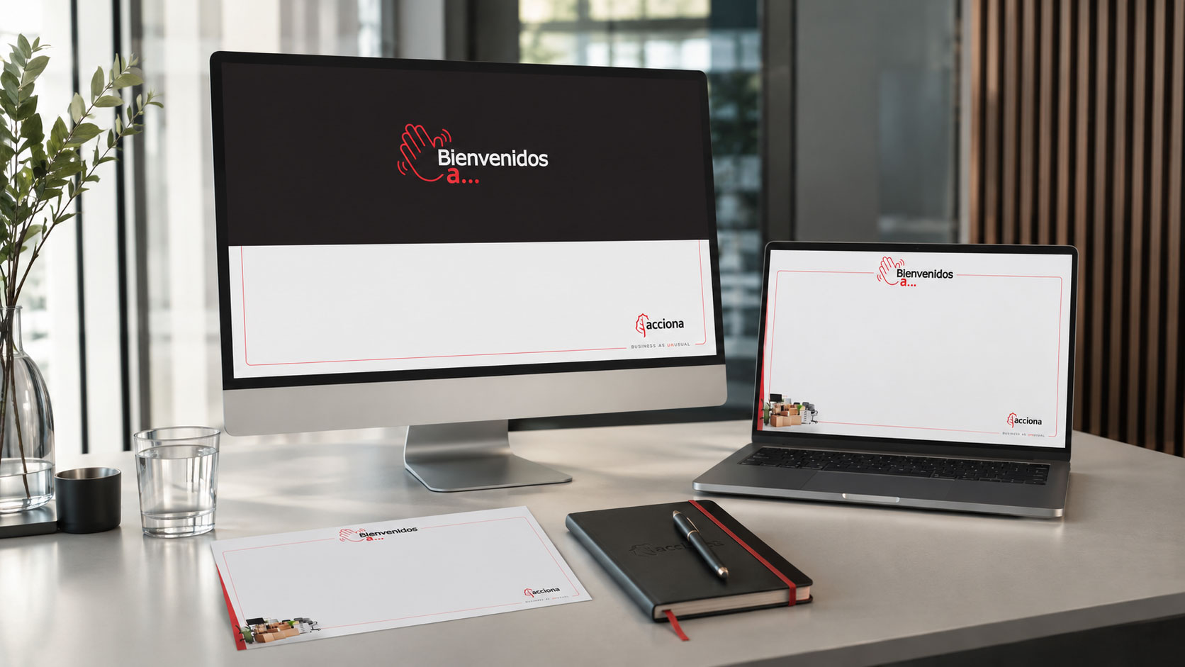 Computadora, laptop y papelería con el sello "Bienvenidos a..." de la campaña de ACCIONA