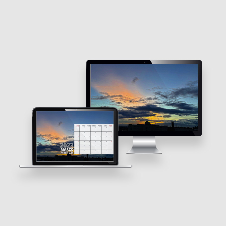 Laptop y monitor de escritorio con un fondo de pantalla de un cielo al atardecer, y un calendario de marzo de 2023 en la laptop