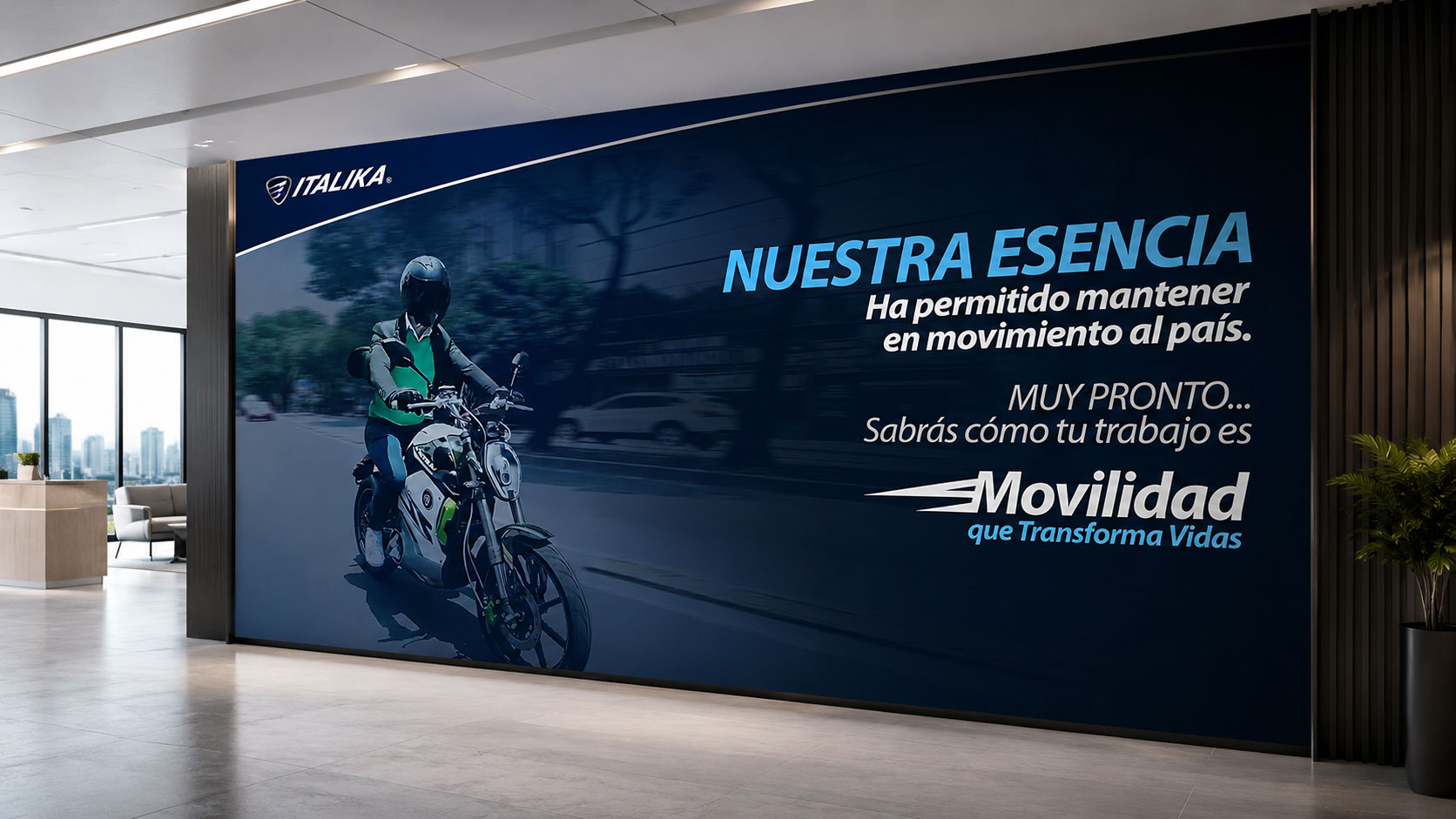Muro de recepción con un repartidor en moto y el mensaje "Nuestra esencia" de la campaña Movilidad que Transforma Vidas