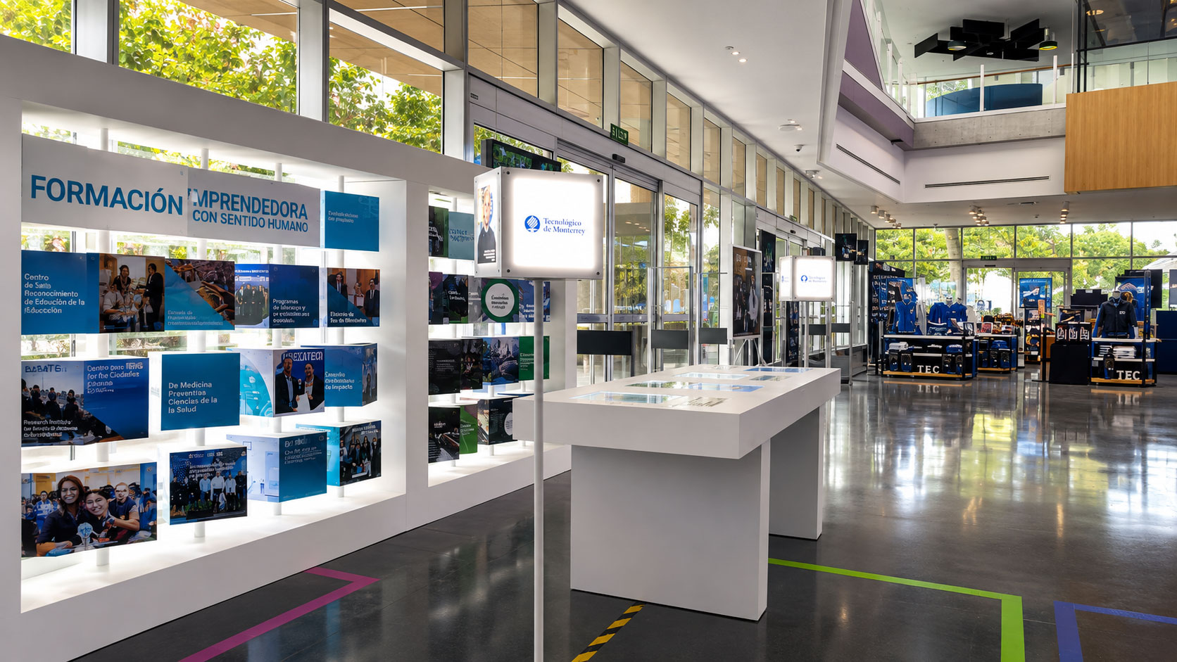 Vitrina blanca con paneles azules "Formación emprendedora con sentido humano" y una mesa de exhibición