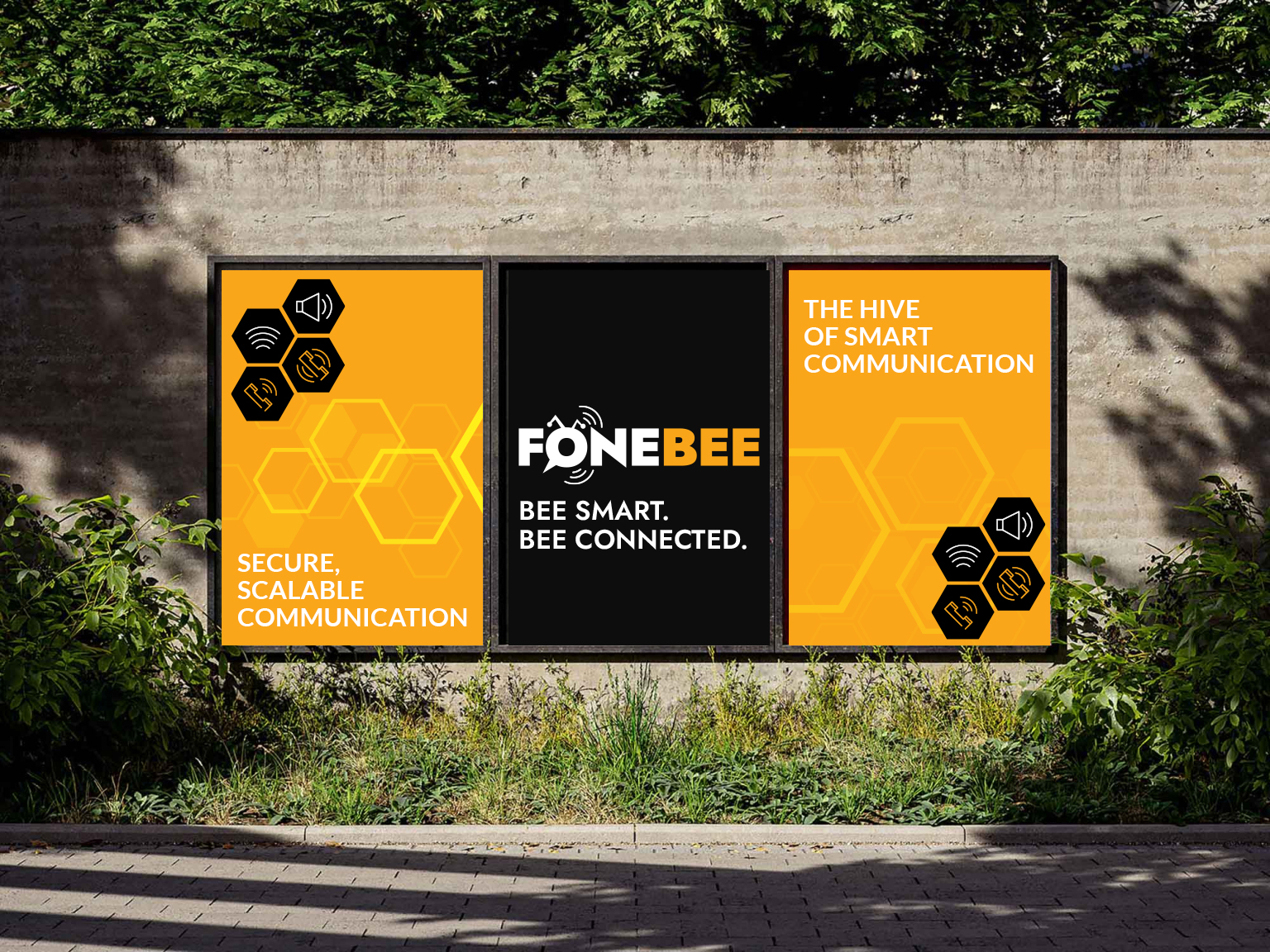 Tres carteles exteriores de Fonebee sobre un muro con el lema "Bee smart. Bee connected."